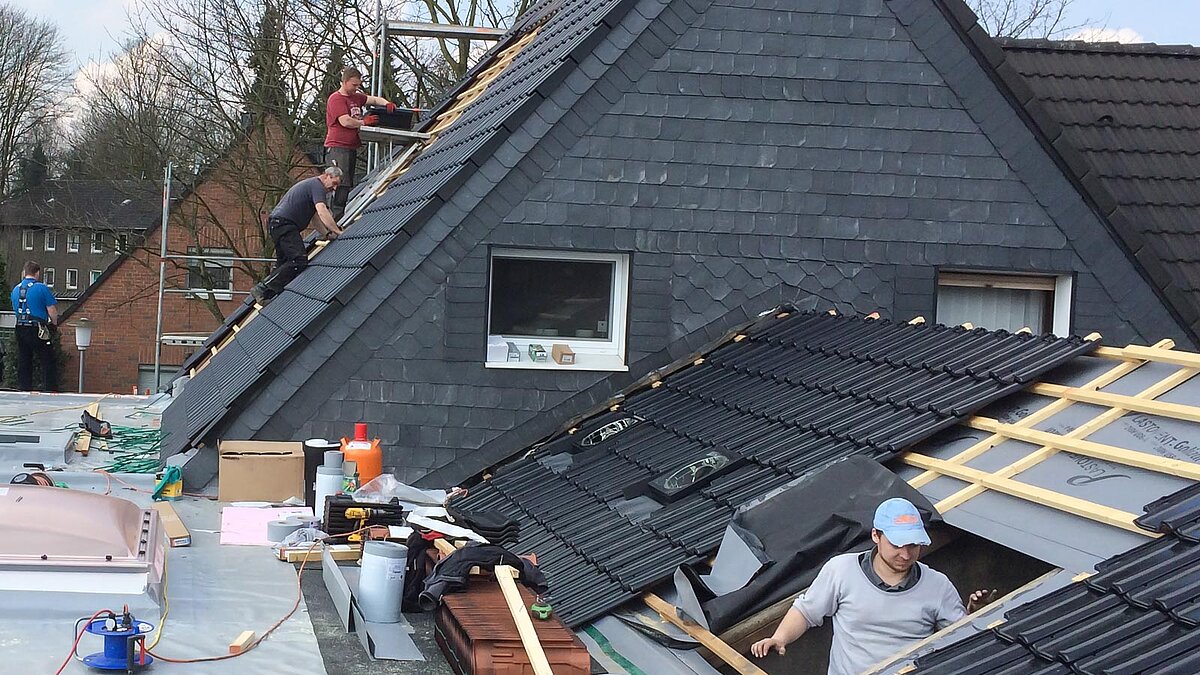 Handwerker auf einem Hausdach