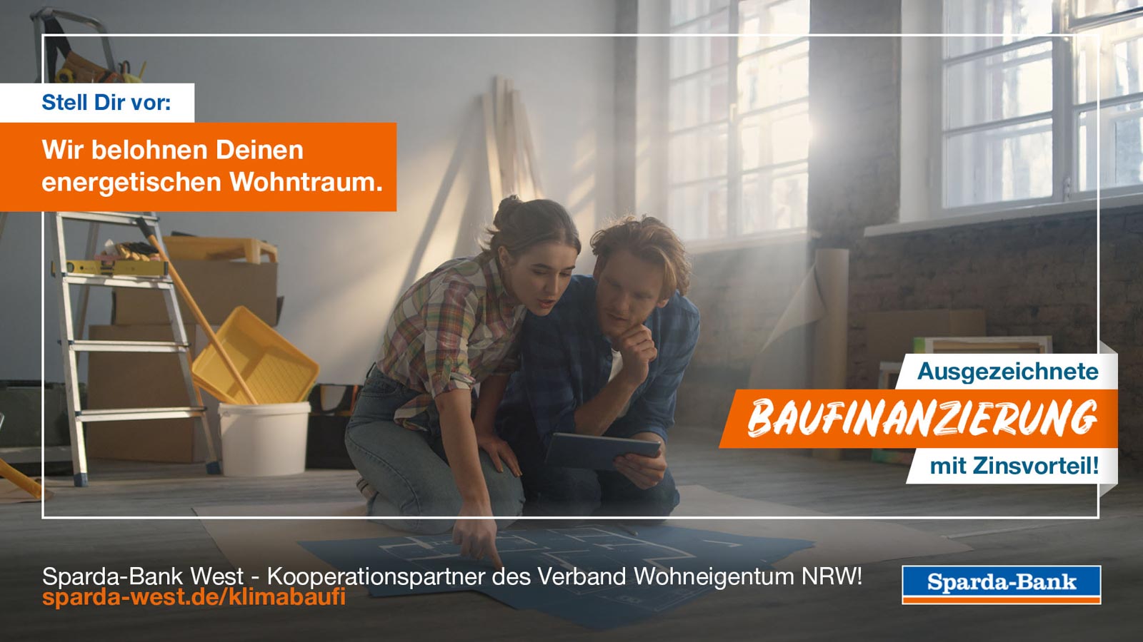 Werbebanner der Sparda-Bank: Junges Paar kniet in einer zu renovierenden Wohnung über Bauplänen