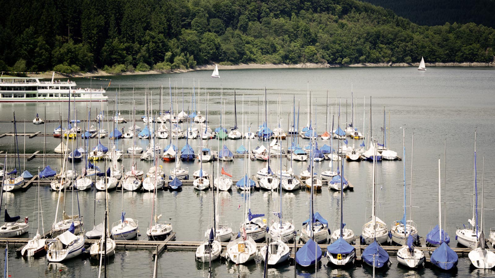 Bild des Biggesees mit kleinen Booten im Hafen