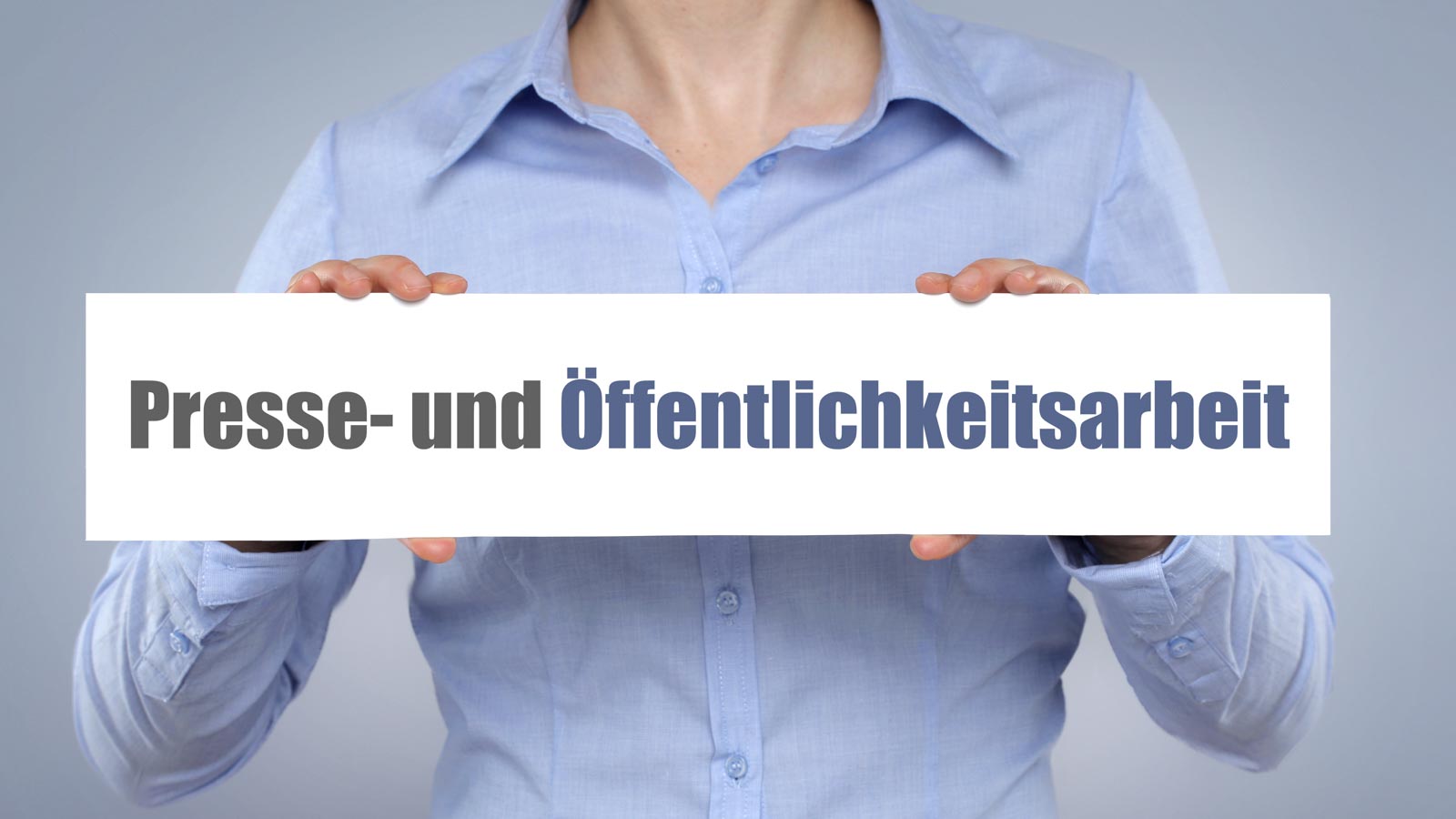 Frau hält Schild mit der Aufschrift Presse- und Öffentlichkeitsarbeit