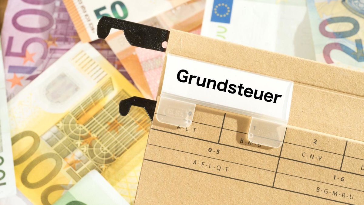 Euro Geldscheine und ein Ordner mit dem Aufdruck Grundsteuer