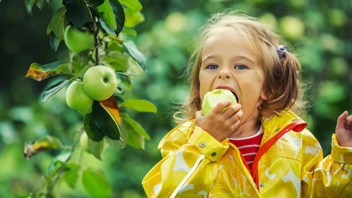 Mädchen beißt in Apfel 