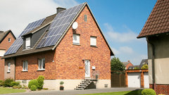 Ein älteres Einfamilienhaus mit Solaranlage auf dem Dach.