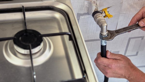 Eine Person möchte die Gasleitung abschalten.