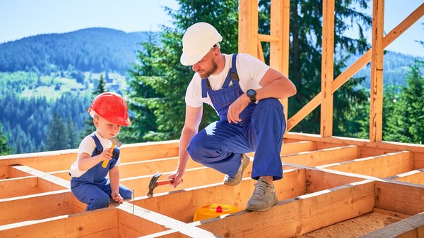 Paar spricht auf einer Baustelle beim Hausbau über Bauherrenversicherung.