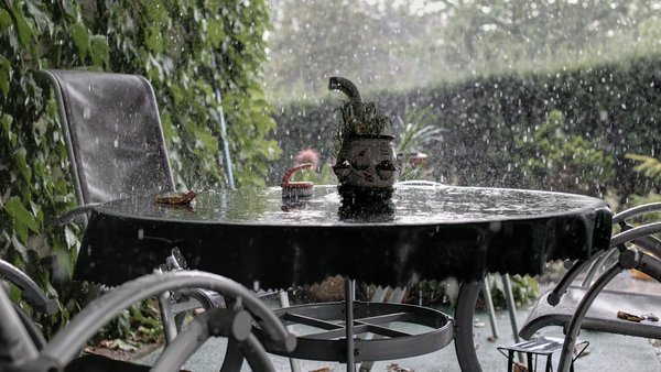 Gartenmöbel auf einer Terrasse in heftigem Regen