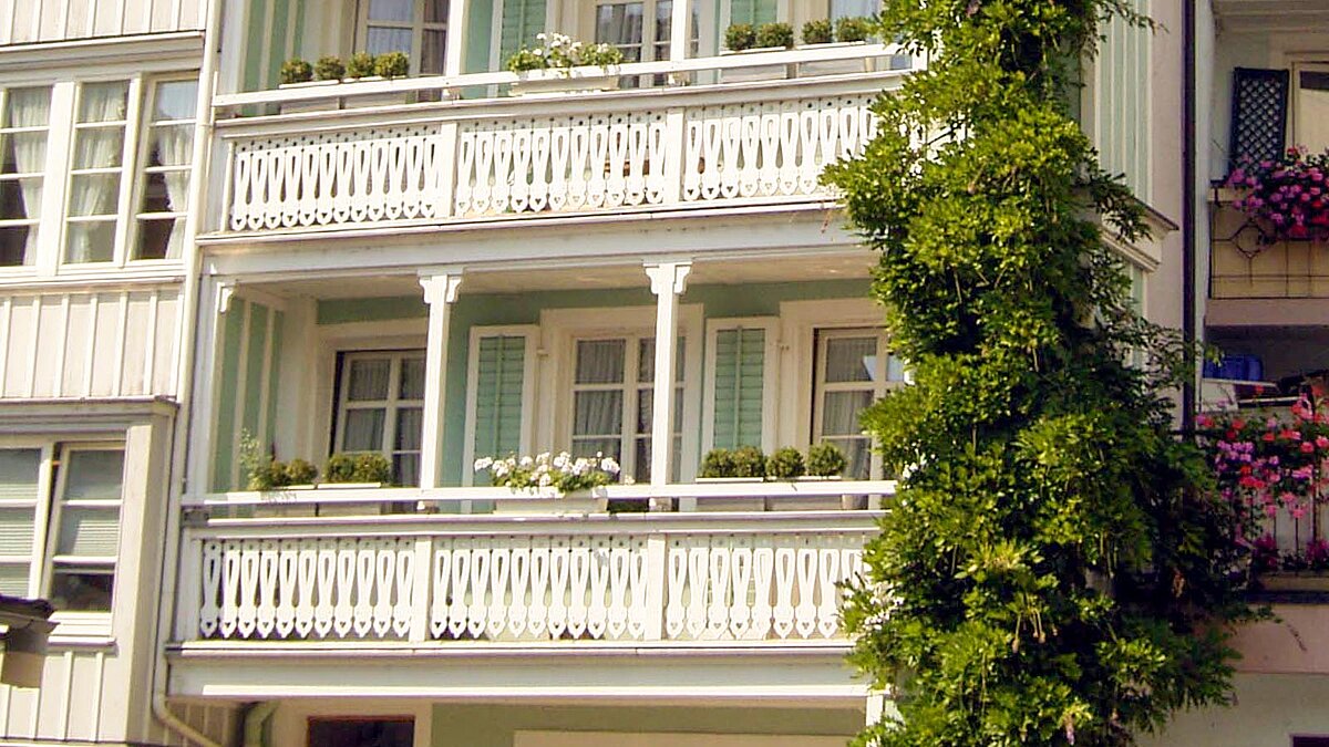 Bepflanzte Balkonkästen an einem Mehrfamilienhaus