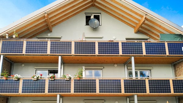 Haus mit Stecker-Solarpanels an allen Balkonbrüstungen