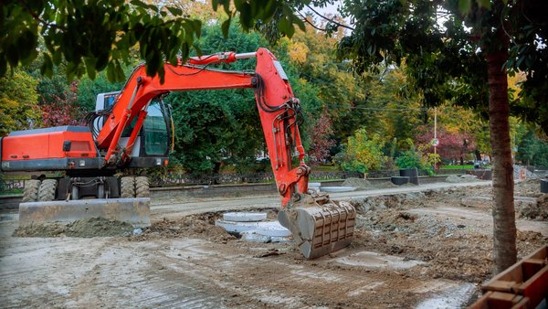 Roter Bagger bei Straßenbauarbeiten