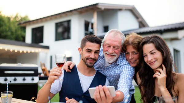 Familie im Garten vor dem eigenen Haus mach ein Selfie