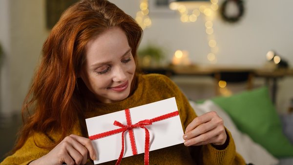 Frau mit einem Geschenkgutschein in der Hand