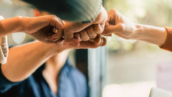 Teamwork – Mehrere Fäuste schlagen ein. 