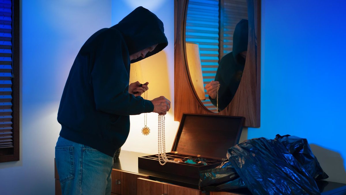 Einbrecher durchsucht in einer Wohnung die Schmuckschatulle