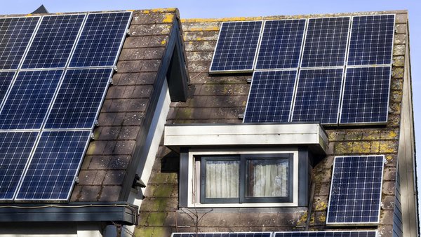 Altes HAus mit Photovoltaikanlage, auf die ein Schatten fällt