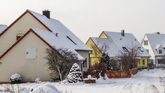 Straßenzug mit schneebedeckten Wohnhäusern