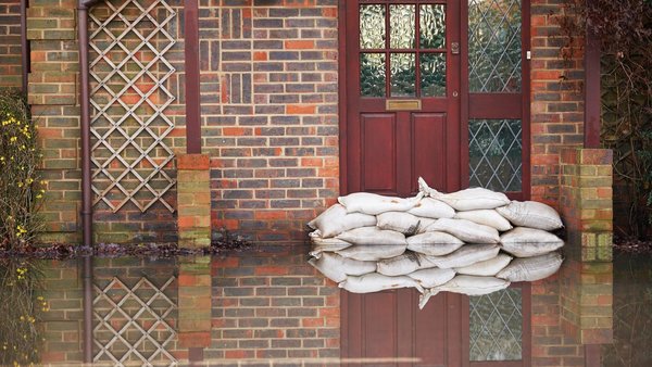 Sandsäcke schützen eine Haustür vor Hochwasser