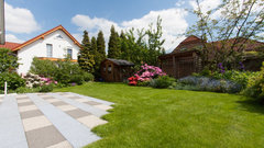 Gepflegter Garten mit grünem Rasen und Terrasse vor einem Einfamilienhaus.