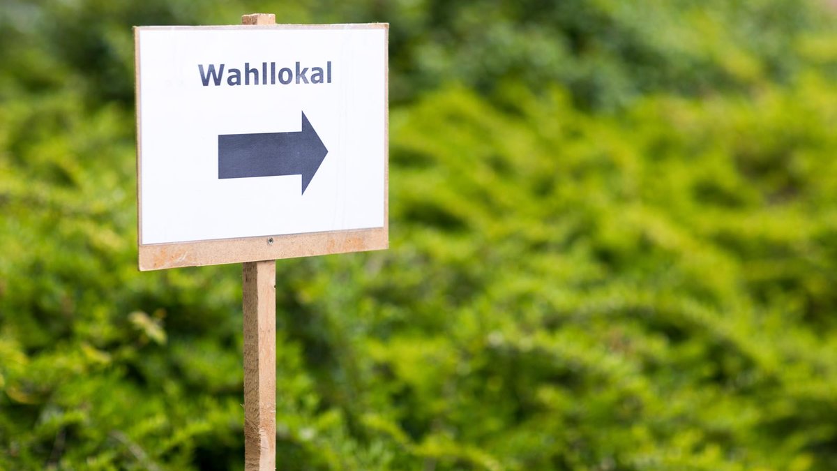 Schild mit einem Wegweiser zum Wahllokal