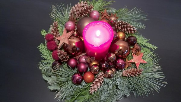 Brand durch Weihnachtsdekoration: Wer zahlt? Adventsgesteck mit echter, brennender Kerze