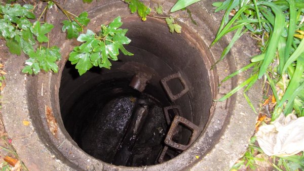 Blick von oben in einen geöffneten Abwasserkanal