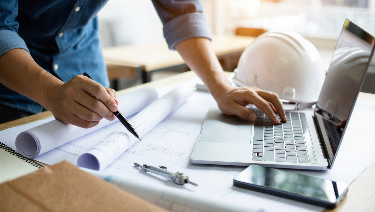 Schreibtisch mit Bauplänen für ein Bauprojekt