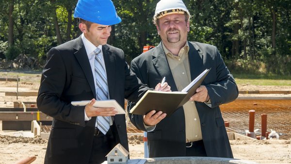 Ingenieur unterzeichnet Leistungen des Handwerkers auf einer Baustelle