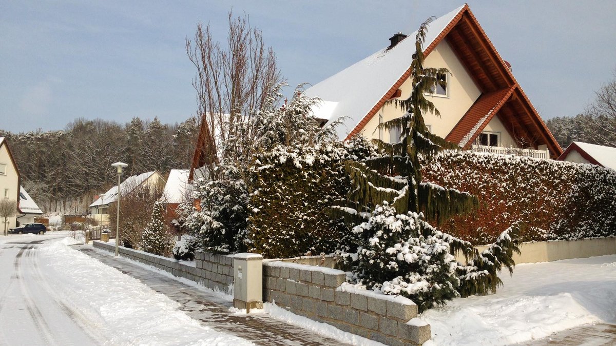 Wintrliches Haus, dessen ZUfahrt und Gehweg vom Schnee geräumt ist