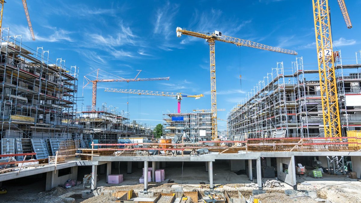 Großbaustelle mit Kränen und eingerüsteten Häusern