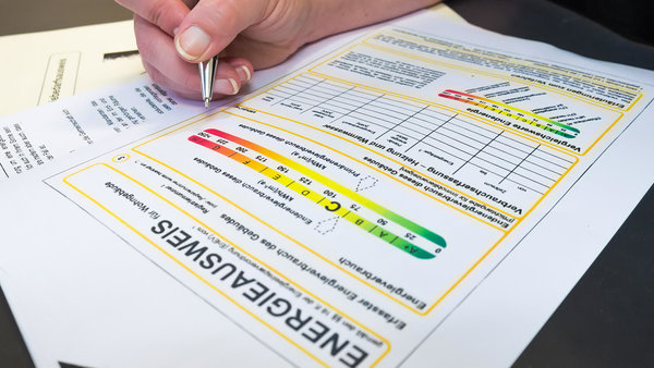 Hand mit Kugelschreiber über einem Energieausweis