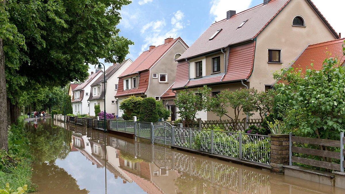 Von Wasser überschwemmte Straße mit Häusern